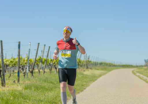 Mann läuft und zeigt einen Daumen nach oben für die Kamera